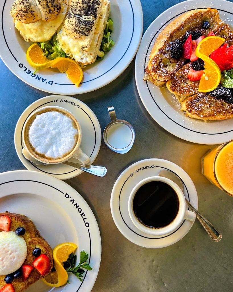 Flatlay breakfast feast with French toast, poached egg sandwich, cappuccino & coffee