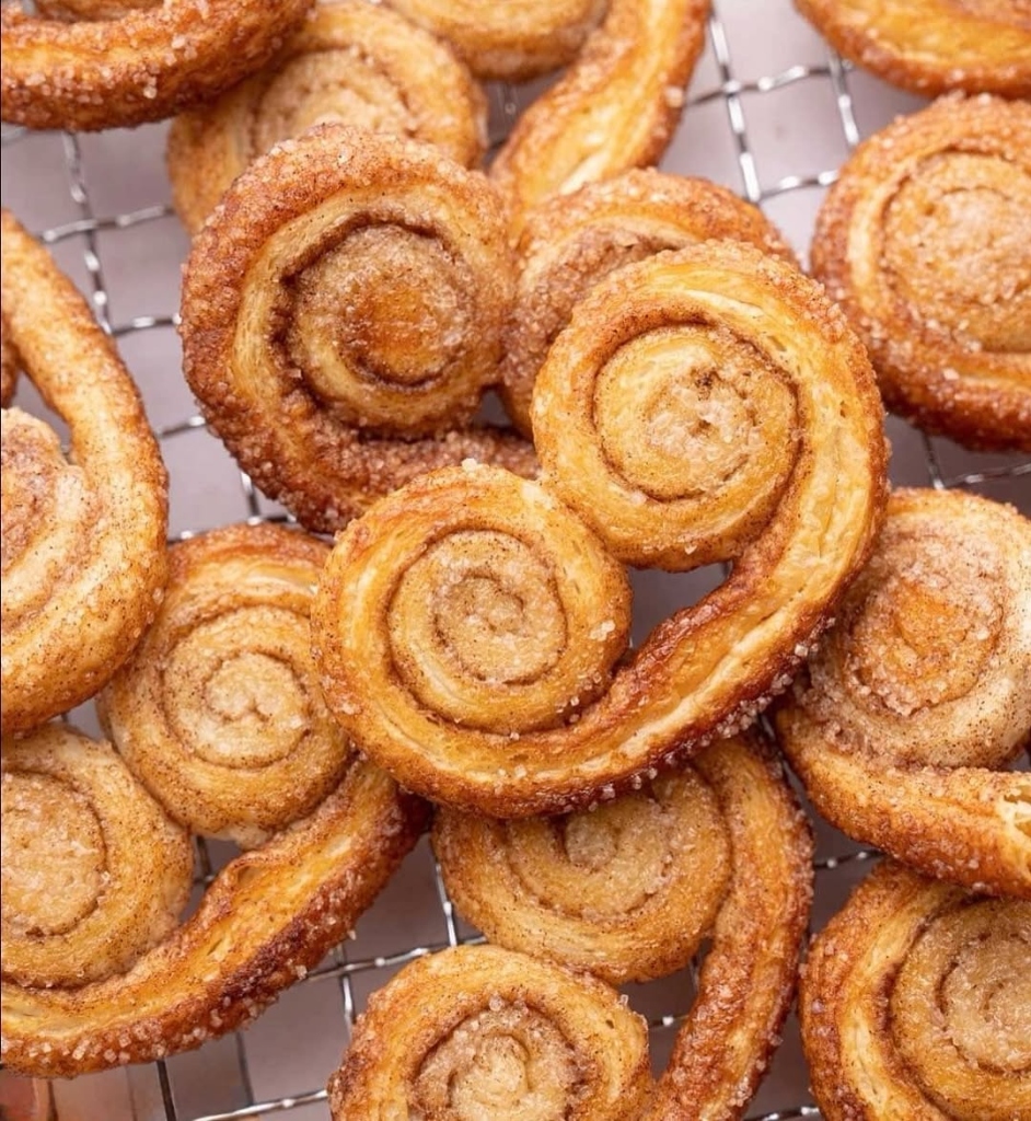 Freshly baked cinnamon sugar palmier pastries cooling on wire rack